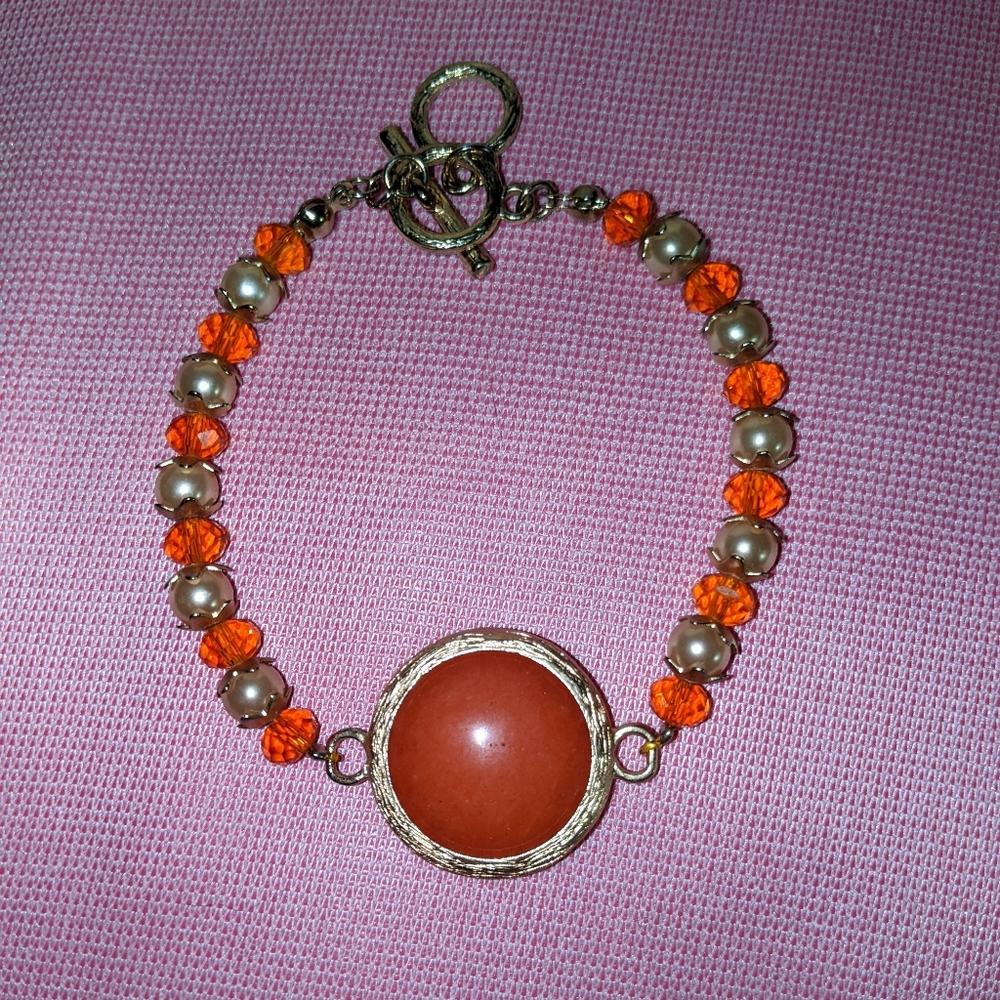 Orange Colored Bead Nestled in a Gold Tone Metal Bracelet